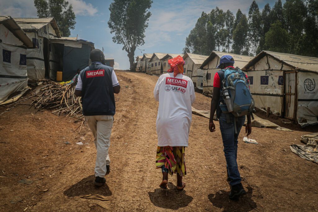 Medair-medewerkers bezoeken een ontheemdenkamp naast een door Medair ondersteund gezondheidscentrum.