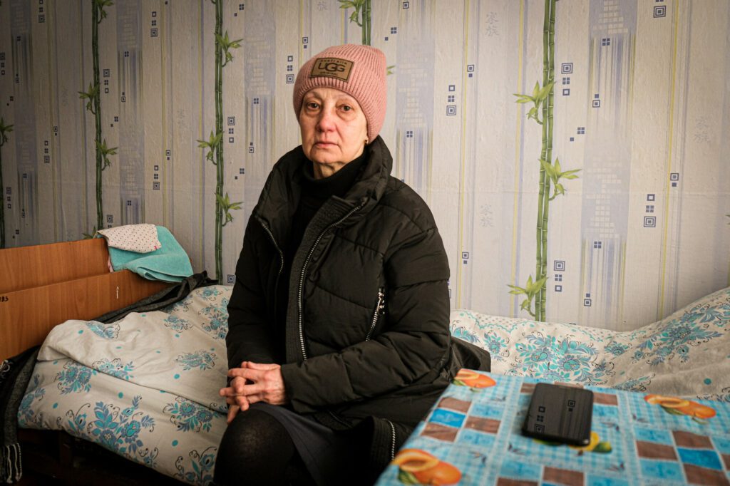 Svitlana, a 61-year-old affected IDP, who lost her home, sitting in her room in Collective Center