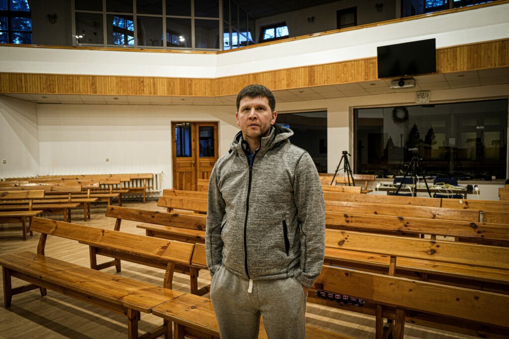 The pastor is standing in empty prayer hall of the church