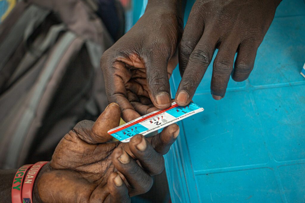 Humanitarian aid worker gives malaria medicine to a patient in South Sudan
