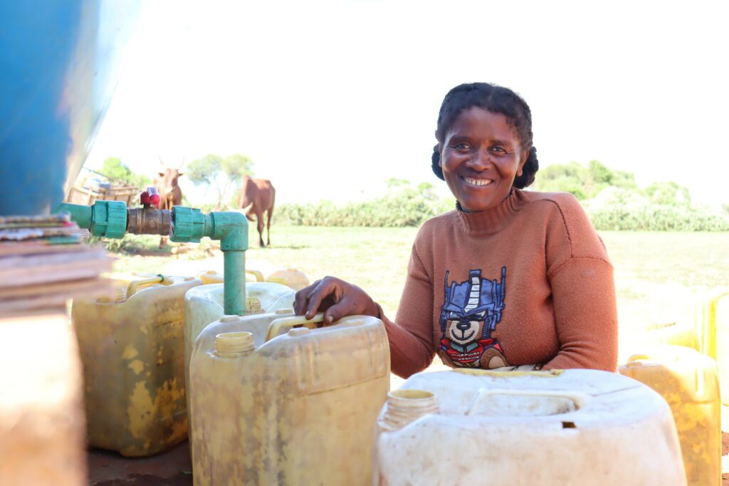 Eine Frau im dürregeplagten Süden Madagaskars ist glücklich, weil sie ihren Kanister mit Wasser von einer Wasserstelle auffüllen kann, anstatt fünf Stunden zum nächsten Fluss laufen zu müssen.