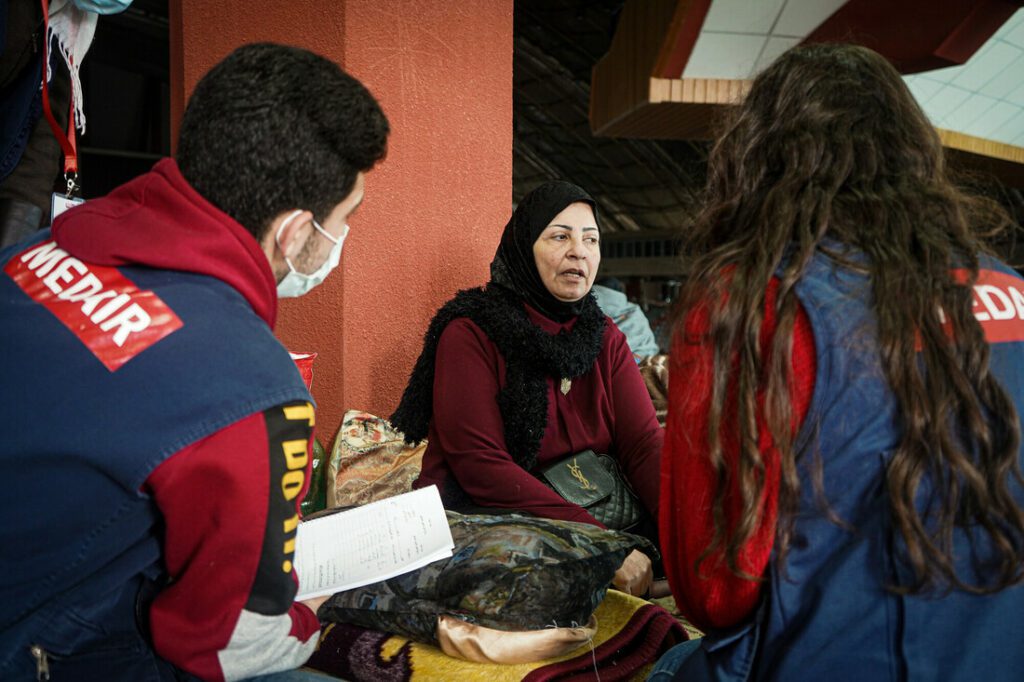 Humanitarian aid workers conduct psychological first-aid sessions with an affected community member.