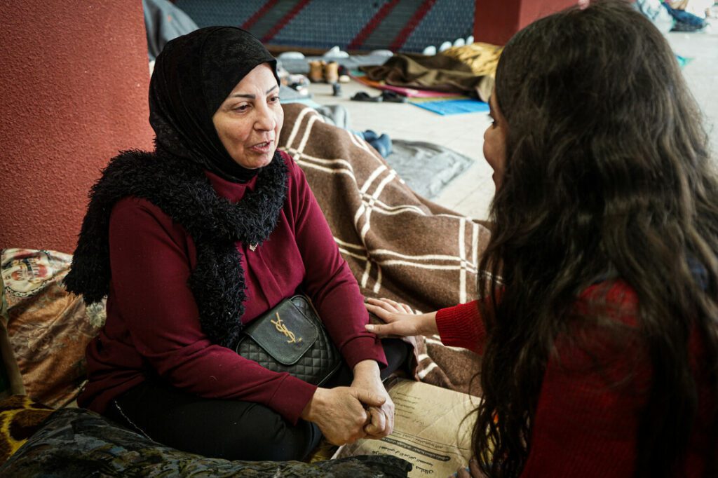 A humanitarian aid worker conducts psychological first-aid sessions with an affected community member.