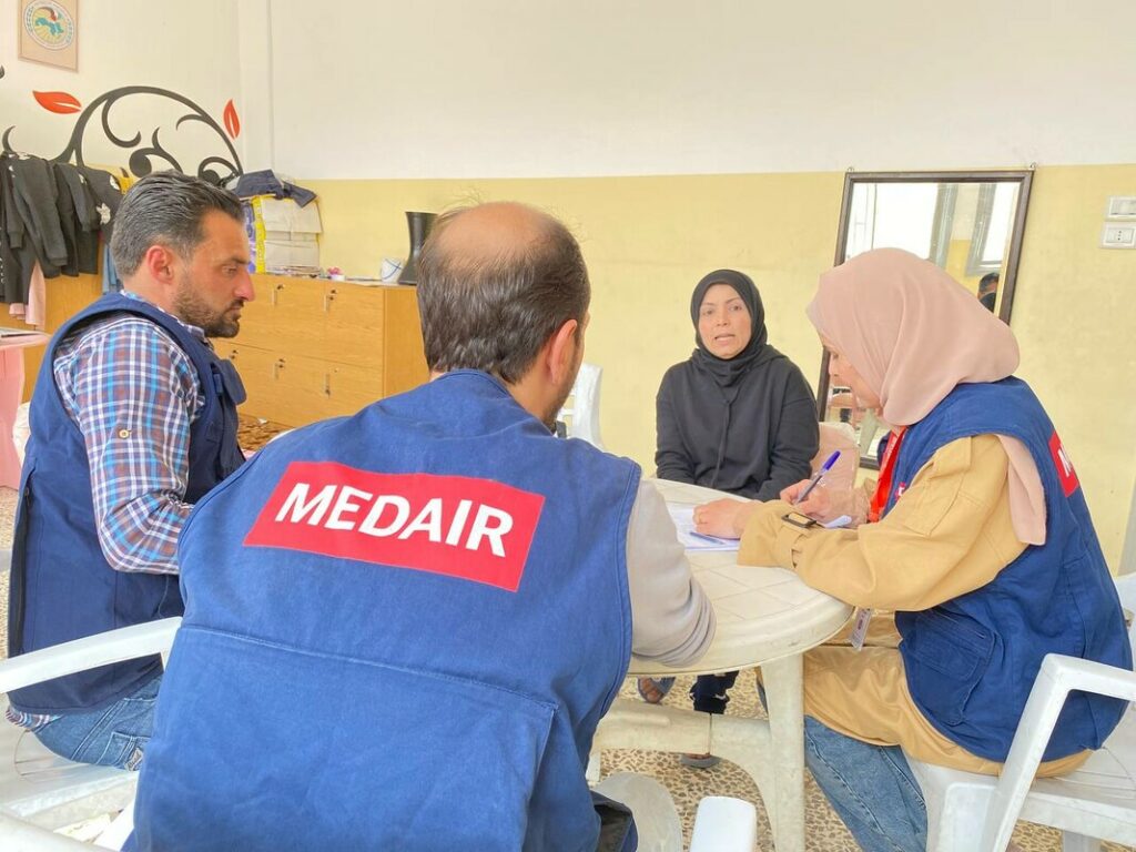 Aida, l'assistante WASH de Medair, prend note des informations sur la situation sanitaire de l'eau fournies par Fatima, la directrice de l'école Takadum Al Arabi à Alep, laquelle fait office d'abri collectif.