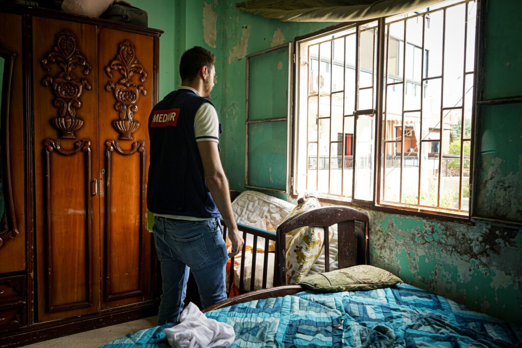 A humanitarian aid worker stands in a room.