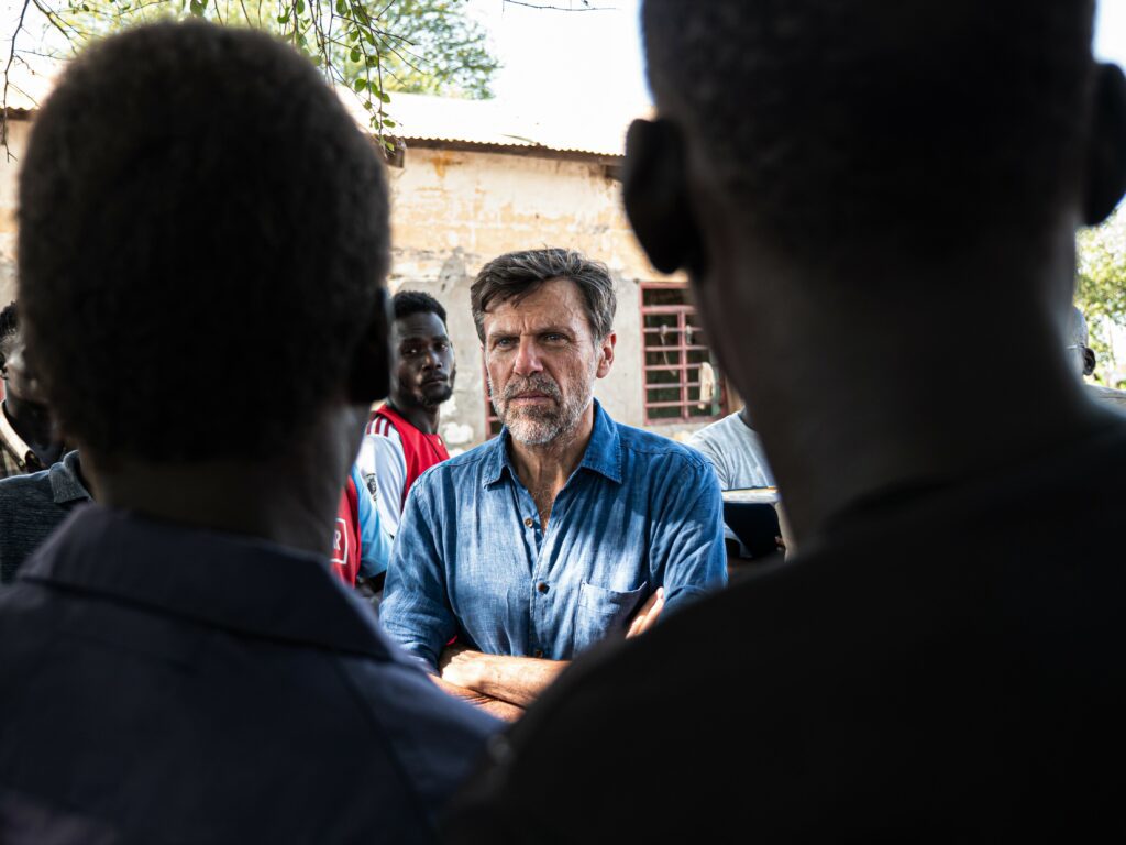 Un travailleur humanitaire discute avec des membres d'une communauté de rapatriés dans un camp près de la ville de Renk, au Sud-Soudan.