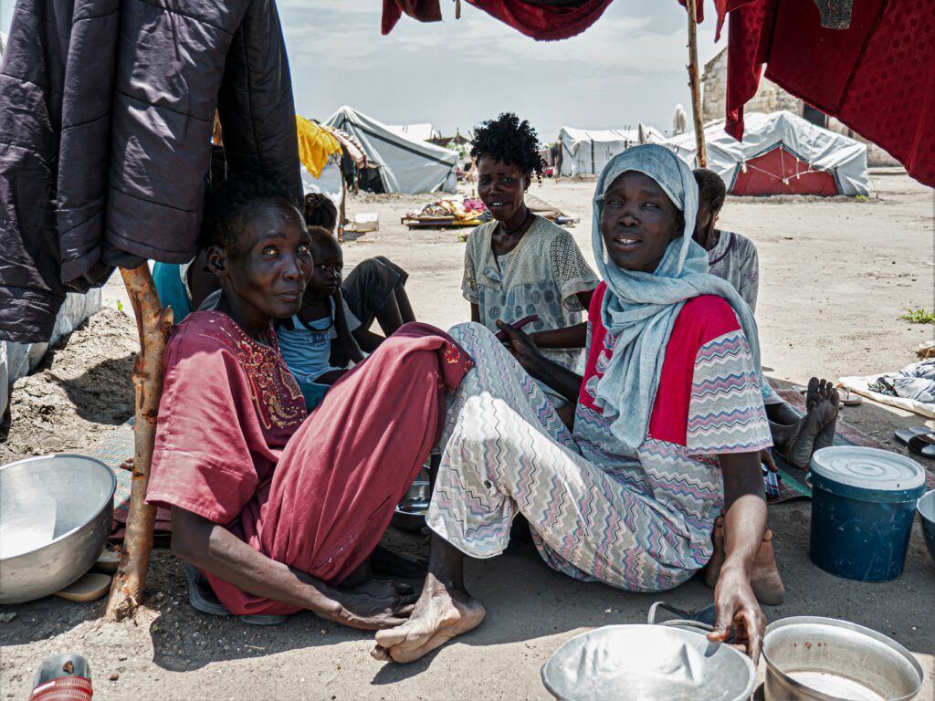 Une famille de rapatriés assise sur le sol dans un camp près de la ville de Renk, au Sud-Soudan.