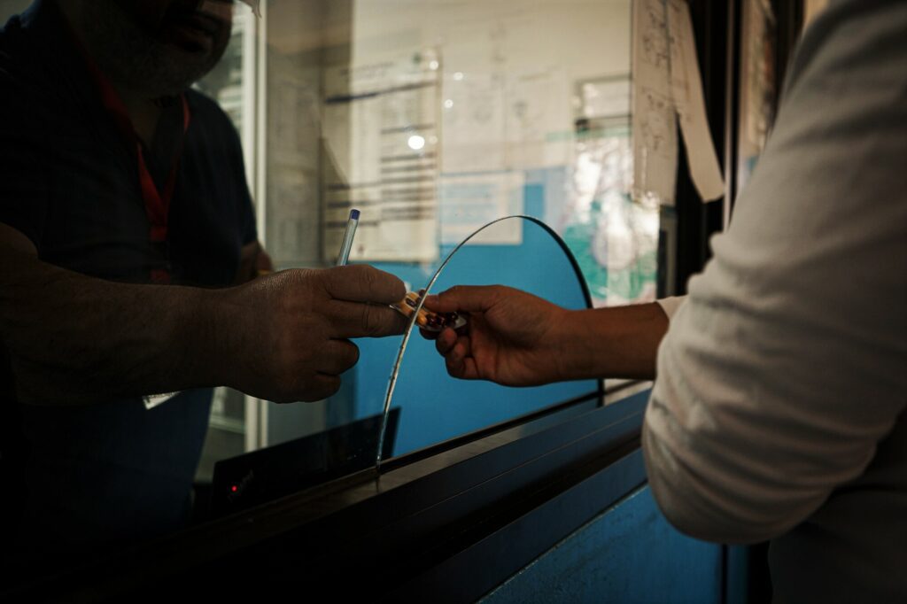 Een apotheker overhandigt een patiënt zijn medicijnen in een basisgezondheidscentrum. 