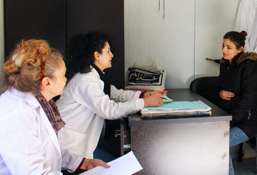 Nawal and Salma, midwives in the clinic, are asking Hanan, the pregnant woman, some questions before the check-up.